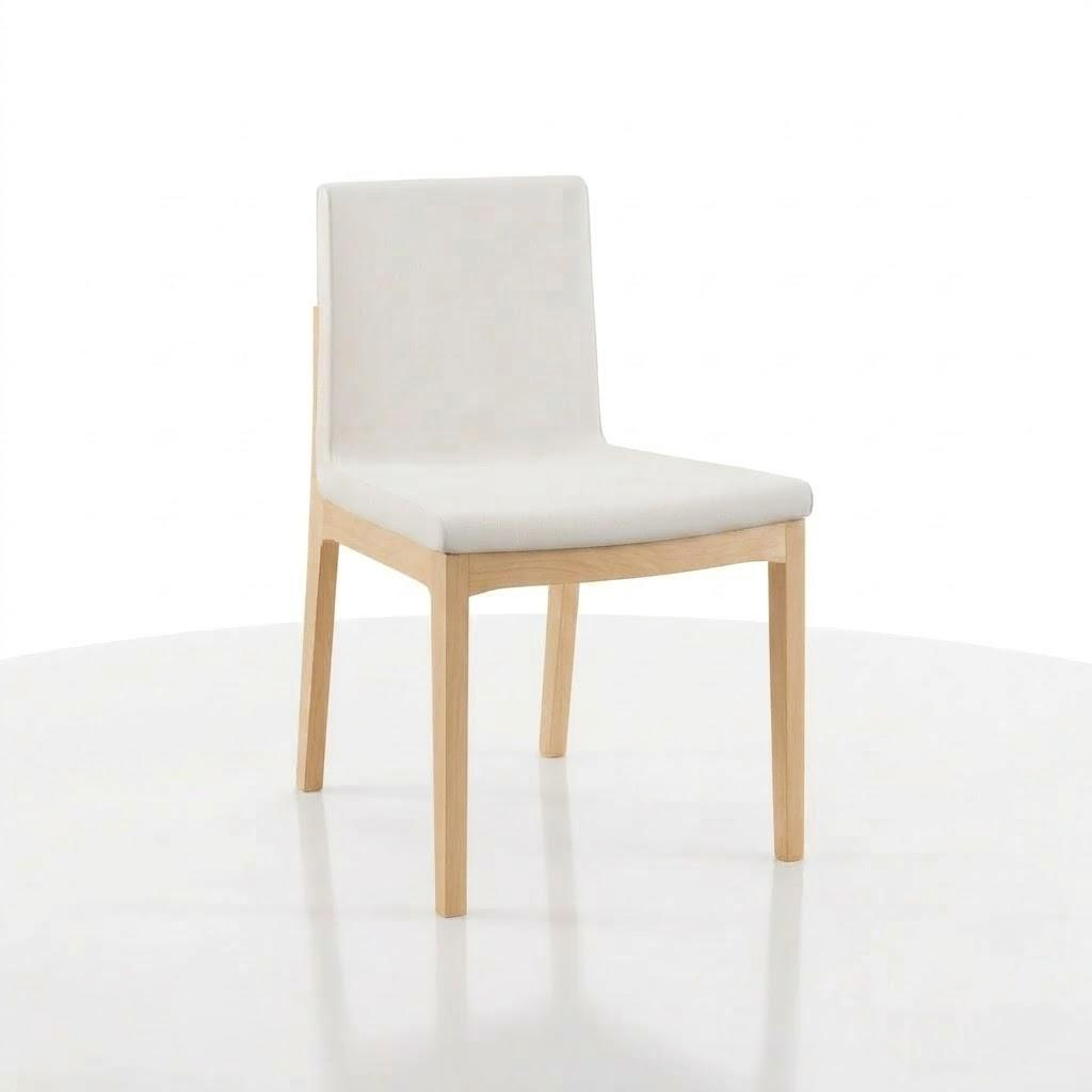 The Carver Chair is a modern wooden chair featuring a light-colored, cushioned seat and backrest, handcrafted in the USA from solid hardwood. It is shown placed on a white surface with a plain white background.