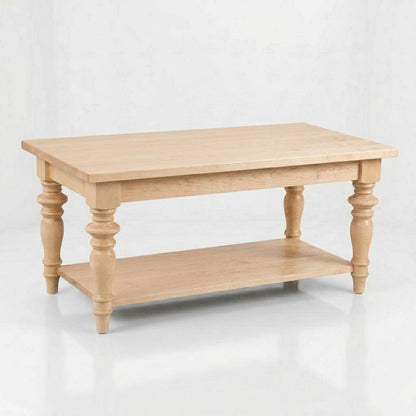 The Lincoln Rectangle Coffee Table, handcrafted from solid wood by skilled American craftsmen, showcases a light wood finish with turned legs and a lower shelf, all protected by a durable top coat and presented against a plain white background.