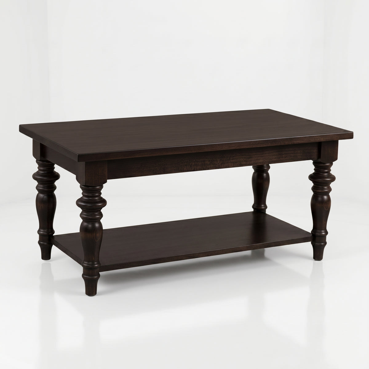 The Lincoln Rectangle Coffee Table, handcrafted from solid wood by skilled American artisans, features a dark wood finish, elegant turned legs, a spacious lower shelf, and a durable top coat—displayed on a white background.
