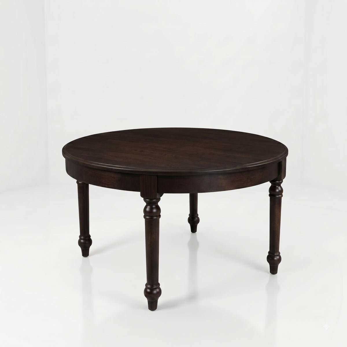 The Marcy Round Coffee Table, a dark brown, round wooden table handcrafted in the USA from solid wood and featuring four turned legs, is set against a plain white background.