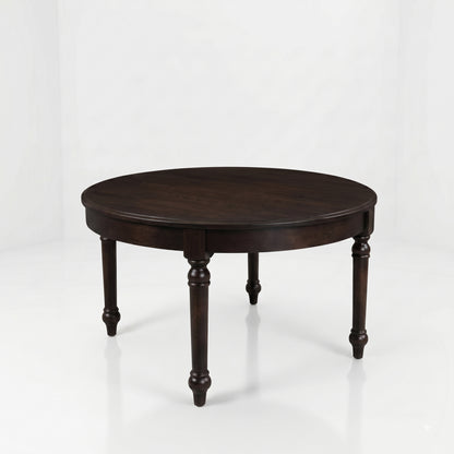 The Marcy Round Coffee Table, a dark brown, round wooden table handcrafted in the USA from solid wood and featuring four turned legs, is set against a plain white background.