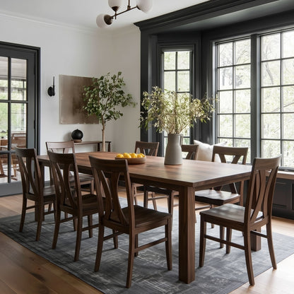 Dining room with wooden solid walnut handcrafted custom usa made table and chairs, large windows, and decorative elements. dark painted trim, blue rug, organic modern