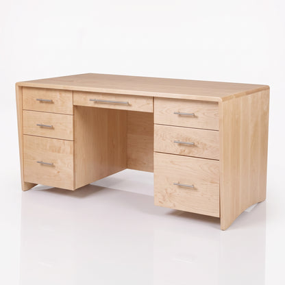 A light natural wood writing desk with a five-drawer left cabinet, three drawers on the right, a center drawer, and an open center space, shown on a white reflective studio floor.