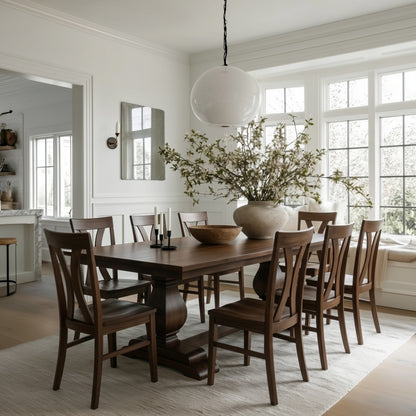 Dining room with wooden walnut handcrafted custom usa build table and chairs, large vase with flowers, and bright windows. oranic modern bright, white rug