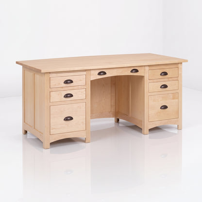 The Owen Hardwood Desk is a handcrafted solid hardwood executive desk with a light-toned rectangular top and seven drawers featuring dark metal cup pulls.