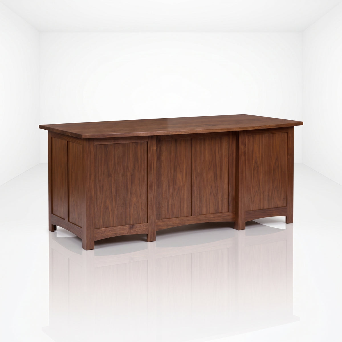 The Owen Hardwood Desk is a handcrafted rectangular wooden desk with paneled sides and a flat top providing desk storage.