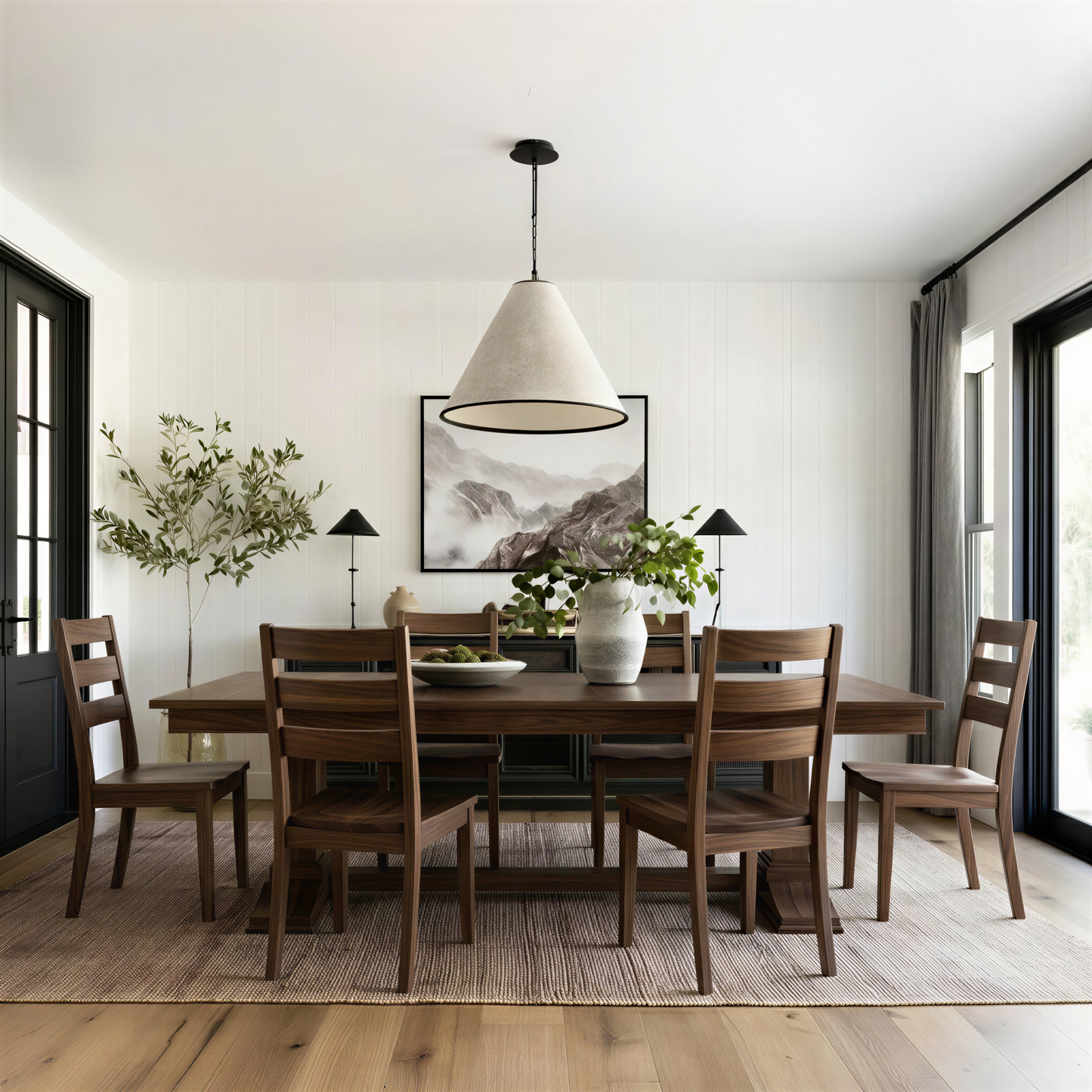 Dining room with wooden table and chairs, modern pendant light, and framed artwork on the wall. Solid handcrafted walnut table and chairs. USA made. extendable.