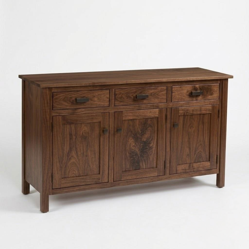 The Rylan Sideboard Table is a handcrafted hardwood piece with three top drawers, three lower cabinet doors, and dark metal hardware.