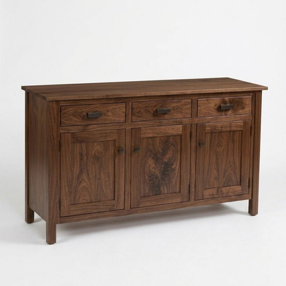 The Rylan Sideboard Table is a handcrafted hardwood piece with three top drawers, three lower cabinet doors, and dark metal hardware.
