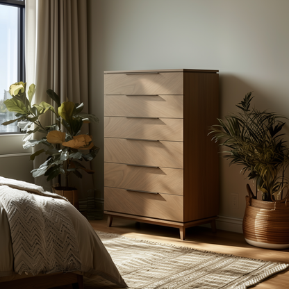 The Adelaide Chest of Drawers, a modern wooden dresser with six drawers, stands beside a bed in a sunlit bedroom, complemented by potted green plants and neutral décor.