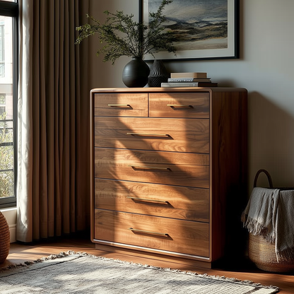 The Eleanor Chest of Drawers with six spacious drawers stands by a sunlit window, topped with a vase of greenery and framed art. A woven basket and light rug nearby complete this cozy, modern bedroom scene.