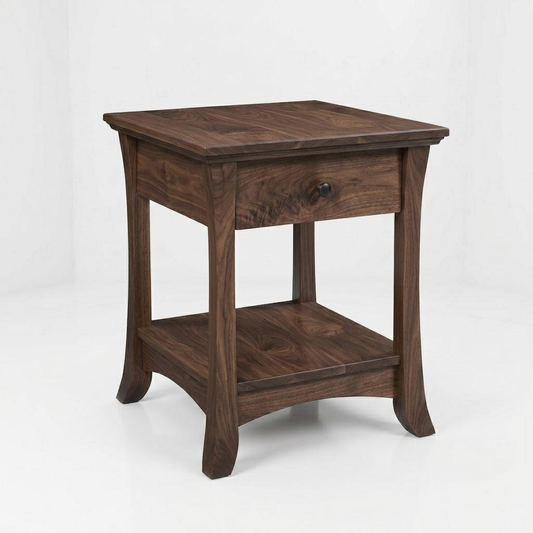 The Veris End Table is handcrafted in the USA from solid wood, featuring a single drawer with a black knob, a lower shelf, and slightly curved legs. Finished in a rich dark tone and protected by a durable top coat, this table is set against a plain white background.