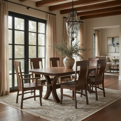 A dining room featuring The Zara Dining Table with six matching chairs on a patterned rug, a large ceramic vase centerpiece, tall windows with beige curtains, and a lantern-style chandelier overhead.